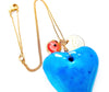 dainty necklace with evil eye bead Persian coin and large blue stone heart